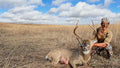 Hunter kneeling beside a harvested deer in Southeast Iowa