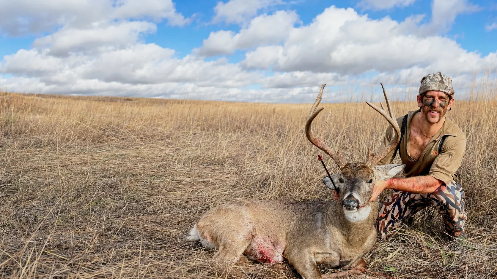 Hunter kneeling beside a harvested deer in Southeast Iowa